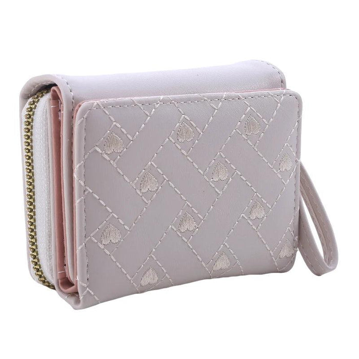 Closed beige wallet with a quilted pattern, showing the side view with a wrist strap and zipper.