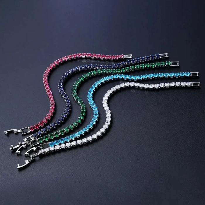 Multiple colorful stone bracelets arranged in a curve on a dark background.