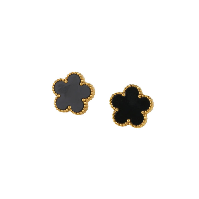 A gold earrings, designed with a flower-shaped pendant with a black center.