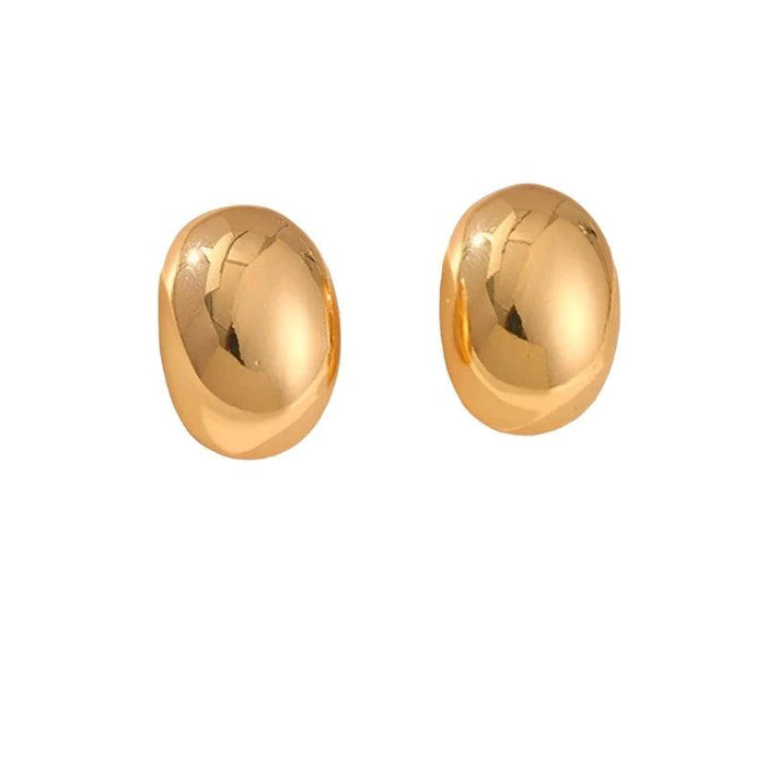 a pair of small, oval-shaped gold stud earrings. Like the silver ones, they have a smooth, reflective surface, highlighting their elegant and classic design. They are also set against a plain white background.