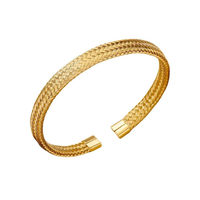 Gold cuff bracelet with a braided texture, displayed on a white background.