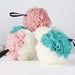 A collection of bath loofahs in pink, blue, and white colors, arranged in a pile against a white background.