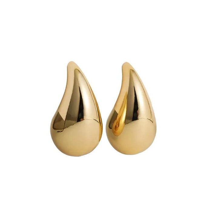 a pair of gold teardrop-shaped earrings. The earrings have a smooth, reflective surface, adding a luxurious and bold touch to their design.