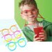 A child wearing red drinking straw glasses and sipping a red drink. Various colors of the straw glasses (orange, pink, yellow, blue) are displayed next to the image.