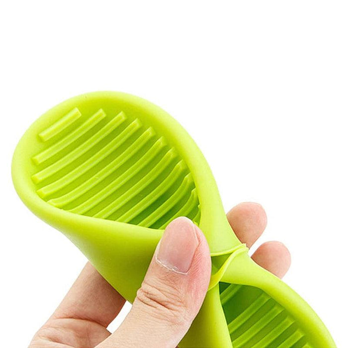 A hand holding a flexible, green silicone oven mitt.