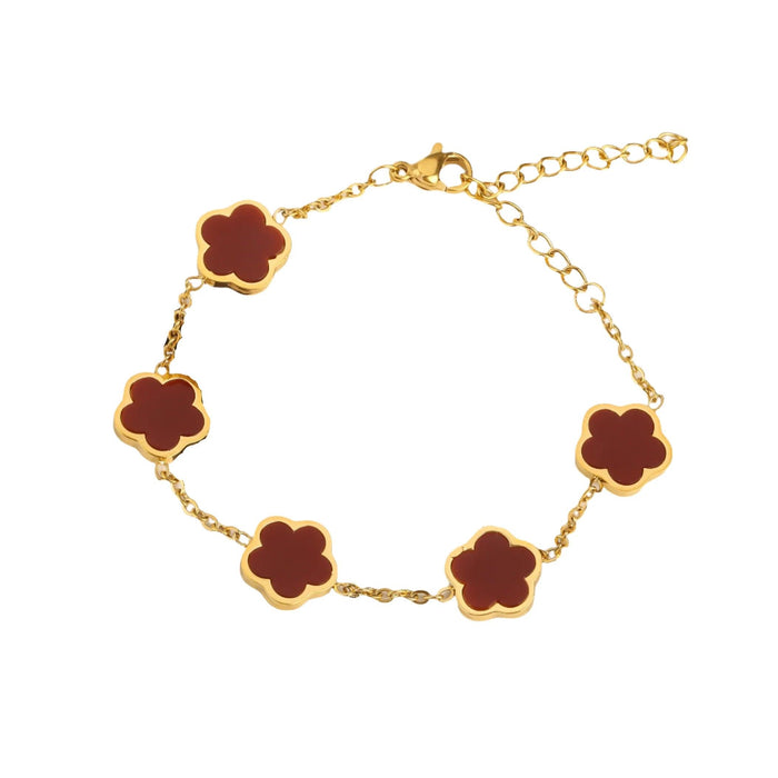 A gold bracelet, designed with a flower-shaped pendant with a red center.