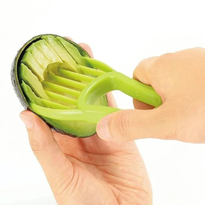 A person using a green avocado slicer to scoop and slice avocado flesh.