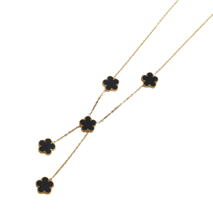 A gold necklace, designed with a flower-shaped pendant with a black center.