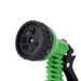 A close-up of the front view of the green garden hose nozzle, displaying its various spray settings.