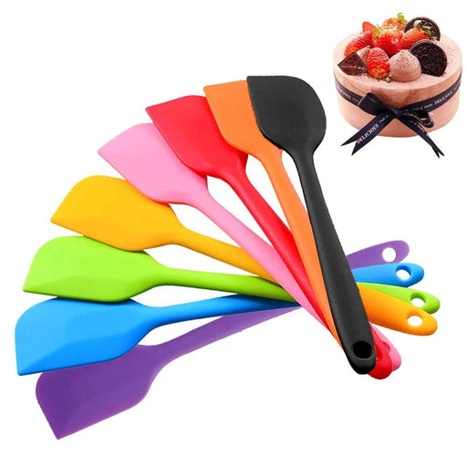 A fan display of colorful silicone spatulas, highlighting their vibrant colors and smooth, flexible design. A cake is shown in the background, suggesting the spatulas' use in baking and cooking.