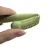 A close-up view of a light green silicone teething stick being squeezed to show its flexible and textured interior.