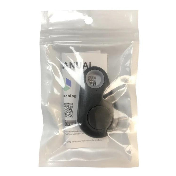 The GPS tracker in black, packaged in a transparent plastic bag. The packaging includes an instruction manual with a QR code visible through the bag. The tracker has a button and a small hole at the top.