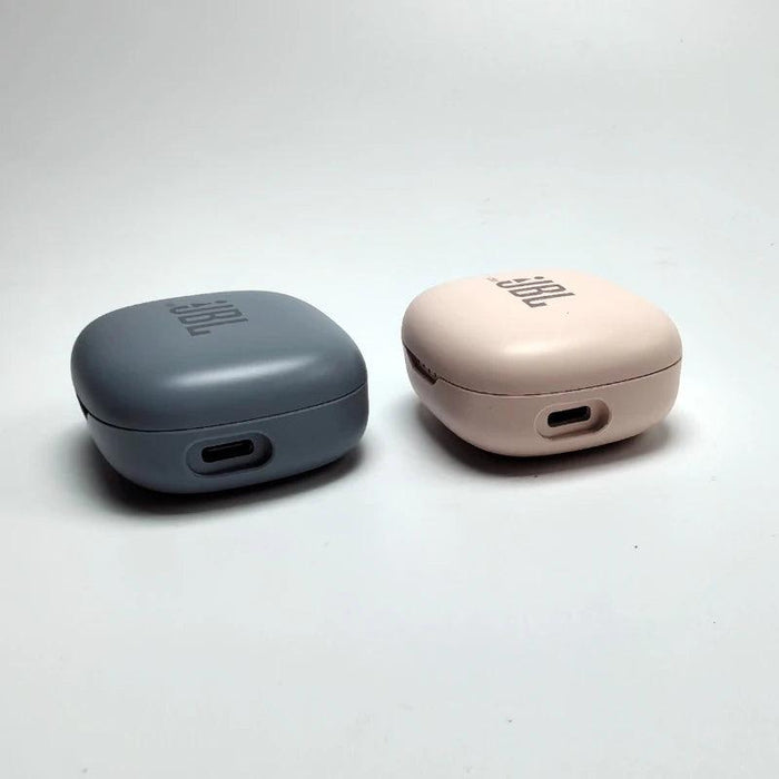 Two closed JBL charging cases in blue and pink, showing their USB charging ports.