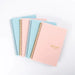 Four spiral-bound weekly planners stacked together, alternating between light blue and pink covers. The planners have "Weekly Planner Non-Dated" text on the front cover in gold.