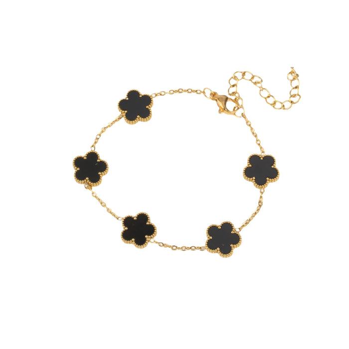 A gold bracelet, designed with a flower-shaped pendant with a black center.