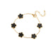 A gold bracelet, designed with a flower-shaped pendant with a black center.