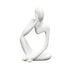 White minimalist abstract sculpture of a figure sitting cross-legged with one arm resting on the head.