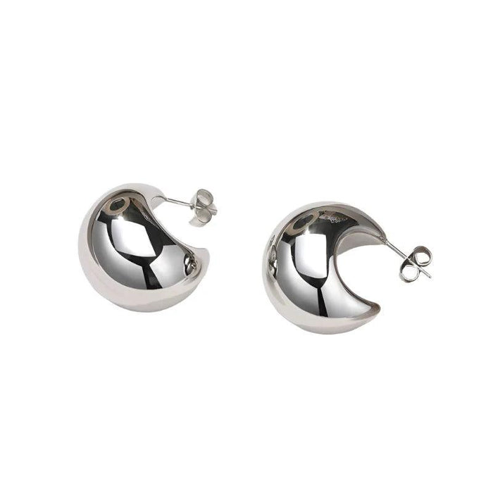 a pair of thick, silver hoop earrings. These earrings have a smooth and polished finish, with a classic and elegant style suitable for various occasions.