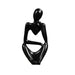 Black minimalist abstract sculpture of a figure sitting with one hand resting on the chin.