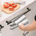  a kitchen counter with a knife and chopped tomatoes on a cutting board. Beneath the counter, there is an over-the-door towel rack in black, holding a striped gray and white kitchen towel. The towel rack is shown as being easy to access, making it practical for kitchen use.