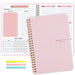 A pink spiral-bound weekly planner with the cover text "Weekly Planner Non-Dated" in gold. The planner is open to show the layout for a weekly schedule and to-do list. Colorful sticky notes are also included in the image.