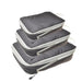 Three dark gray packing cubes with gray zippers and handles, stacked on top of each other. Each cube has a zipper pull with a black tab.