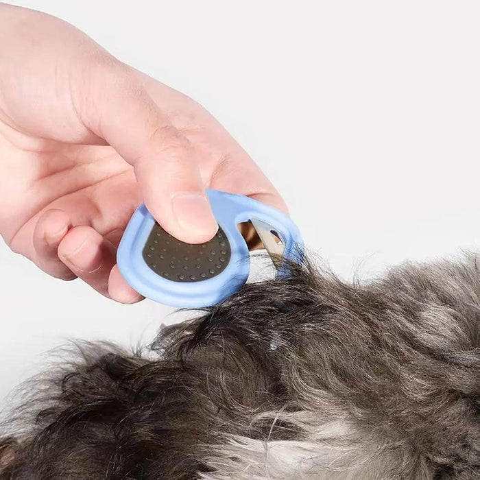 Hands using the blue grooming tool on a pet's fur, demonstrating its effectiveness.