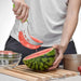 A person is using the watermelon slicer to cut and lift a watermelon slice, showing the ease of use and effective slicing capability.