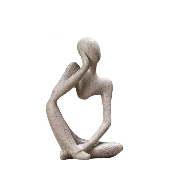 Sand color minimalist abstract sculpture of a figure sitting cross-legged with one arm resting on the head.