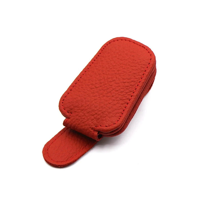 Red leather clip with a magnetic closure, lying flat.