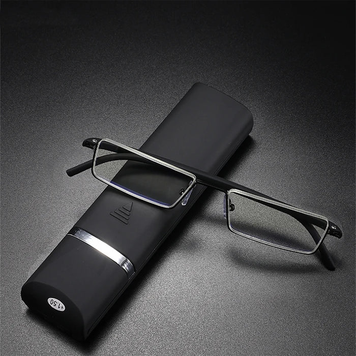 A pair of rectangular eyeglasses with thin, black frames and clear lenses is positioned atop a black eyeglass case with a silver accent. The case and glasses rest on a textured, dark gray surface.