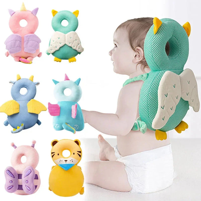 A baby sitting and wearing a green owl-shaped head protector with yellow feet and detailed wings, alongside six other colorful baby head protector designs.