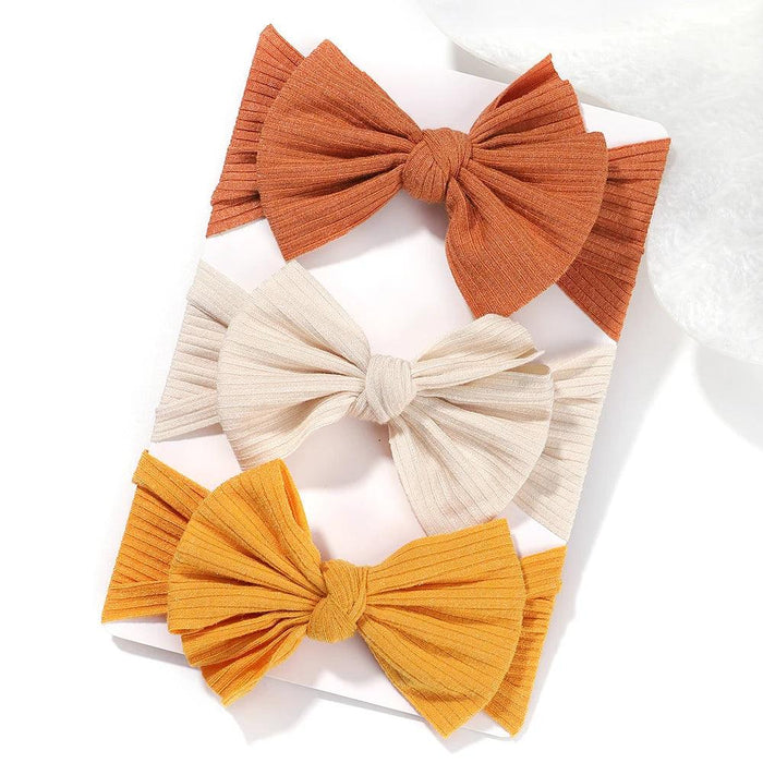 A set of 3 Baby Bow Headbands with different colors.