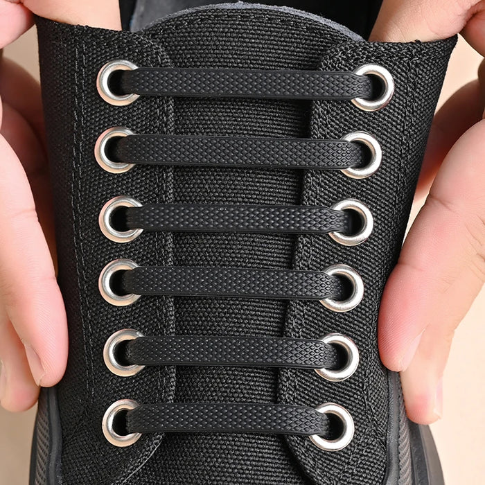 Black sneaker with fully installed no-tie elastic shoelaces.