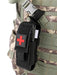 A black medical pouch with a red cross attached to a camouflage tactical vest, showing the tourniquet inside.