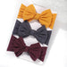 A set of 3 Baby Bow Headbands with different colors.