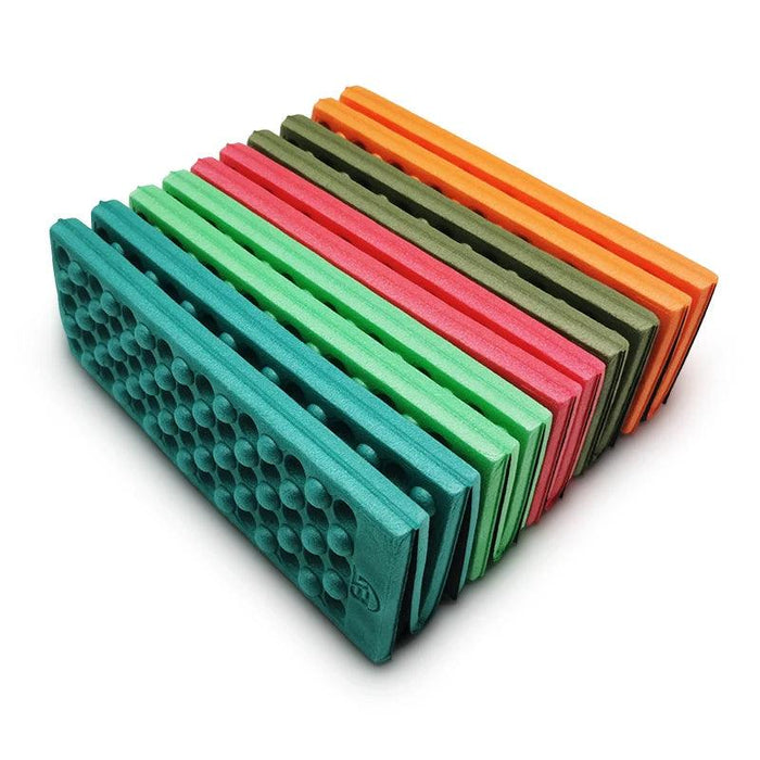 Colorful Foldable Foam Mats: A stack of colorful foldable foam mats arranged side by side. The mats are in various colors, including teal, green, pink, orange, and olive, each with a textured surface for extra comfort and durability.