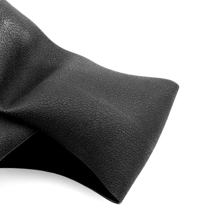 Textured black rubber sheet with a slight fold, highlighting its surface pattern and flexibility.